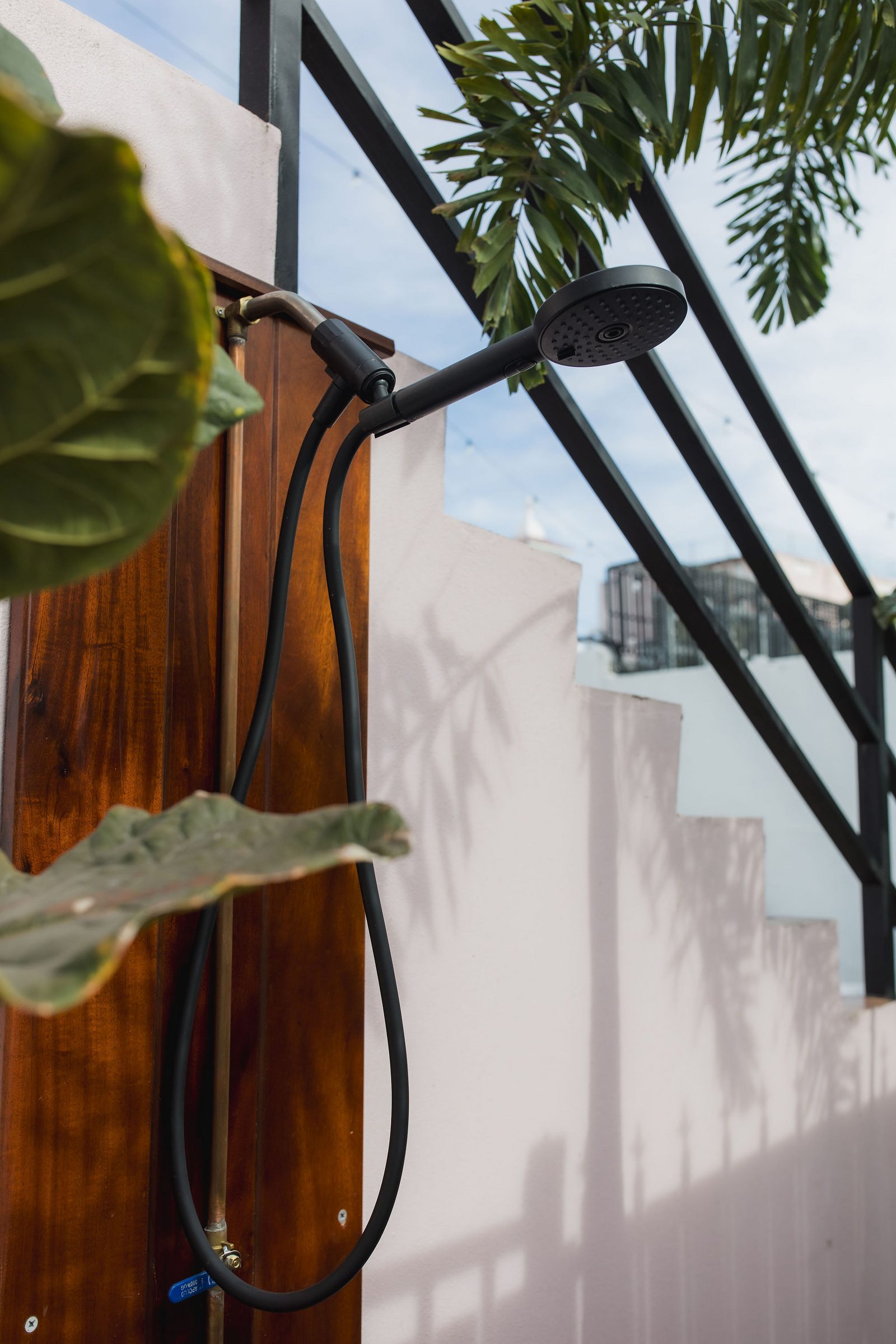 Outdoor shower at Hotel Luz surrounded by tropical palm leaves